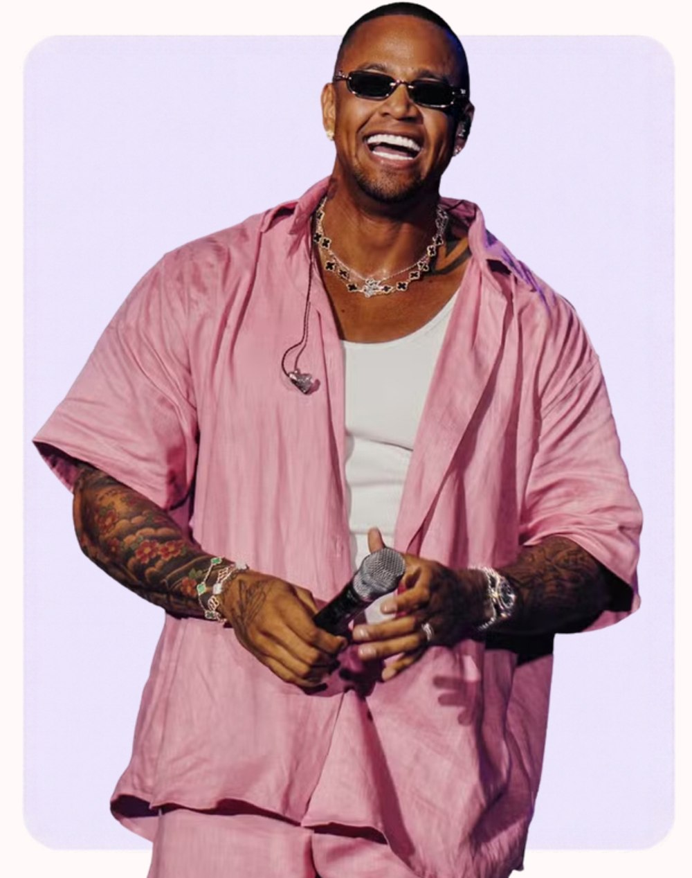 Léo Santana smiling on stage in a pink shirt